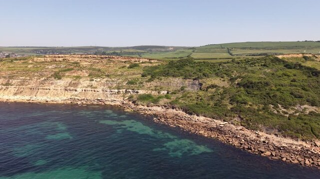 Aerial drone footage of Redcliff Point on the Dorset coast, showcasing striking coastal cliffs, rugged shoreline, and panoramic views of the English Channel