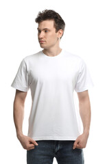 Obraz premium Handsome young man wearing blank t-shirt on white background. Mockup for design