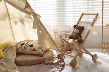 Cute wigwam with fairy lights and toys in stylish child's room © New Africa