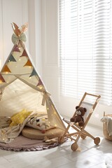 Cute wigwam with fairy lights and toys in stylish child's room © New Africa