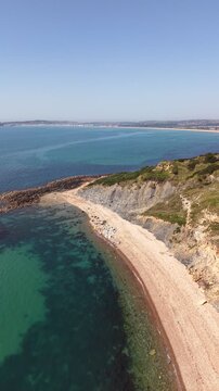 Aerial drone footage of Redcliff Point on the Dorset coast, showcasing striking coastal cliffs, rugged shoreline, and panoramic views of the English Channel