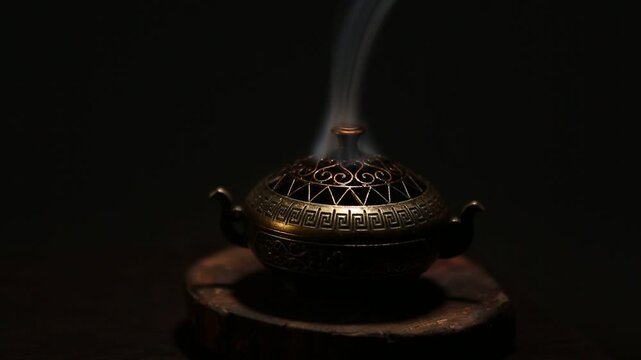 Blue texture smoke from incense aroma stick in vintage old design metal box motion rising above on copy space dark background. Meditation, yoga, wellness, aroma calm relaxation concept