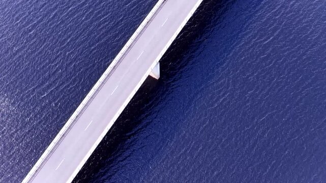 Bradshaw bridge on Burbury lake in Tasmania aerial vertical panorama to mountains and sky.
