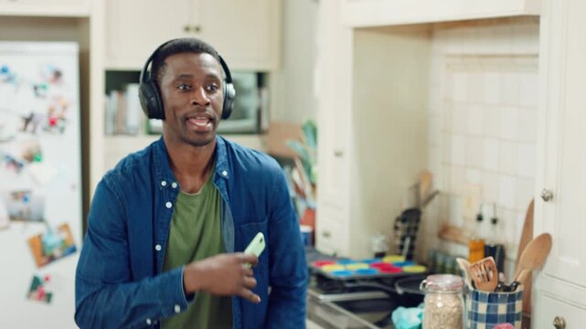 Dance, happy and black man with headphones in kitchen with energy, audio and streaming. Weekend, relax and person with music for movement, rhythm and sound for good mood, positivity and break in home