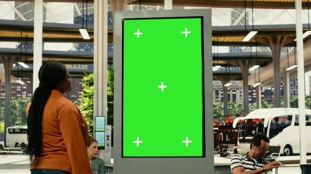 Green screen in public transportation station with passengers during weekday commute in a busy city environment. Human flow and movement create realistic urban lifestyle scene.