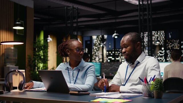 Black business team uniting forces and solving administrative tasks, ensuring strategy planning for project management. Man and woman colleagues sharing business intel for research.