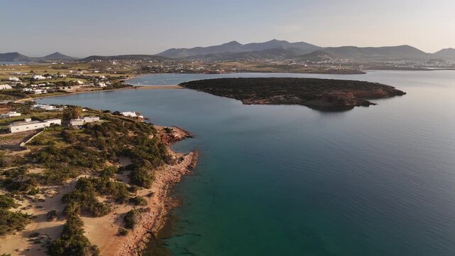 4K aerial view of a vibrant wild peninsula and crystal turquoise bay on Paros Island, Greece