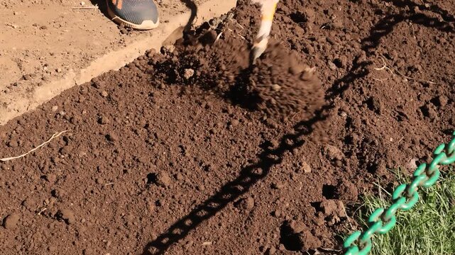 Close up of rake working soil texture during field preparation for planting