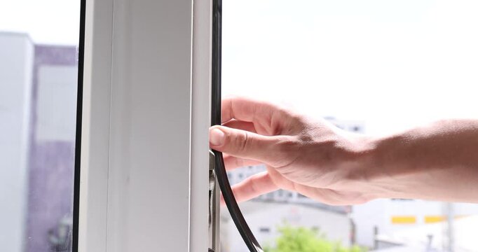 Handyman installing rubber gasket on window indoors, closeup
