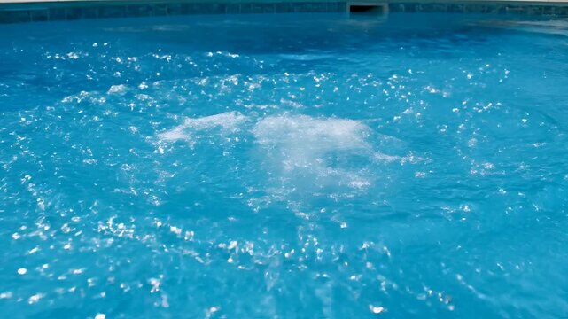 Closeup of water swirling in a swimming pool creating a vortex effect.