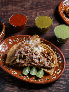 Mexican gringa with pork, cheese, salsa and lime overhead view