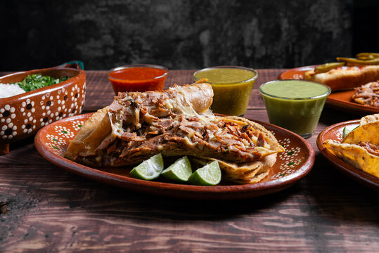Mexican gringa with pork, cheese, salsa and lime overhead view