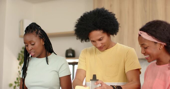 African American family scanning bowls grating on grater mixing sauce in eggs making meal at island