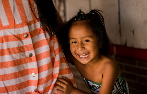 Ni&ntilde;a sonriente abrazando a su madre en un momento de cari&ntilde;o y felicidad familiar