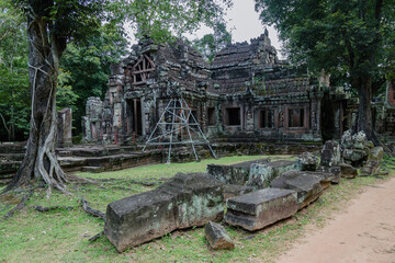 Obraz premium The ancient stone ruins of Banteay Kdei temple in Siem Reap, Cambodia, are overgrown with lush green jungle foliage, showcasing its historical significance.