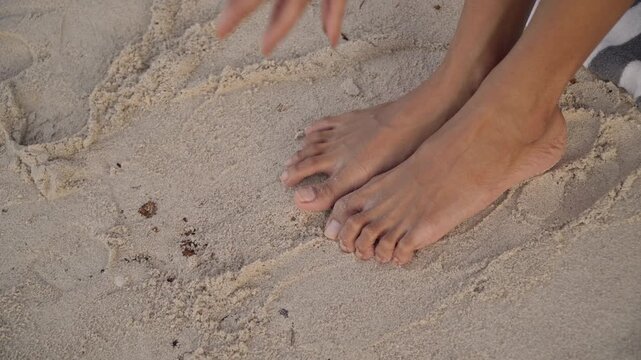 Boho shell sandals on sand, closeup of feet removing ornate shell footwear, gentle grains between toes, golden light, anklet and jewelry detail, soft breeze, pedicure and vacation mood, tactile sand