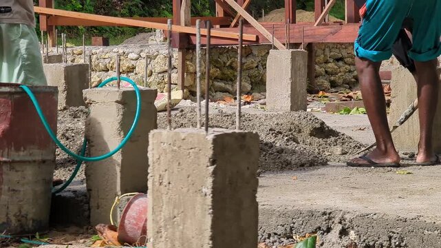 Close-up footage of a construction worker mixing sand and cement at a building site. Ideal for masonry, concrete preparation, construction materials, and infrastructure development concepts.