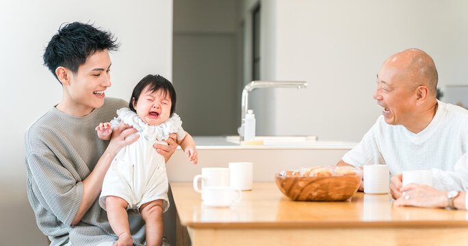 A father comforting a crying, fussy baby; a father and grandfather.