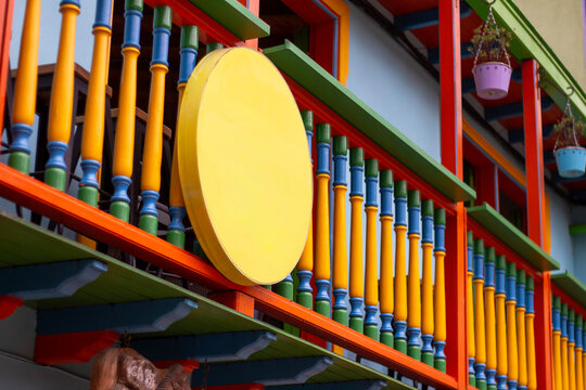 Fachada de comercio con circulo amarillo y barandal de colores 
