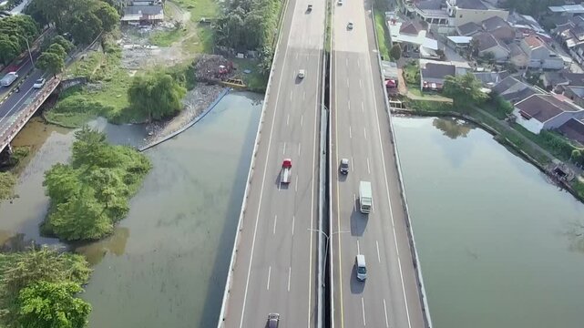 Aerial Drone View of Urban Toll Road Crossing Waterway with Light Traffic in Daylight