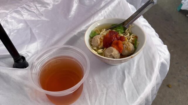 Traditional Indonesian bakso meatball soup served with iced tea
