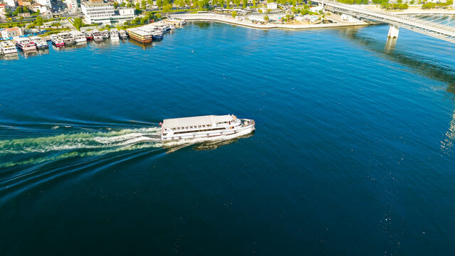 Istanbul, Turkey. Public transport ferry passing under Golden Horn Metro Bridge in Golden Horn Bay at morning sunlight. Aerial View