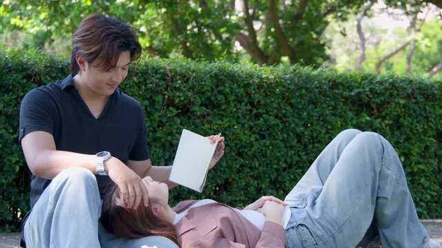 Young Asian University Students Relaxing and Reading Books in Campus Park