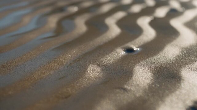 Wavy sand patterns on beach shore.