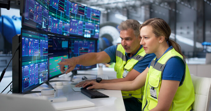 Two Operators Monitor Power Plant Control Screens