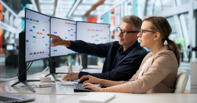 Two Business Professionals Discuss Automated Workflow System Improvements