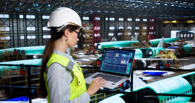 Young Female Engineer Inspects Aircraft Systems Using Laptop