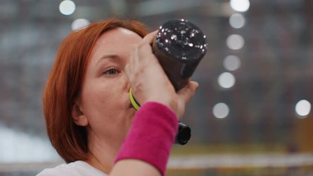 Female sportswoman concentrates before warmup. Preparations for game involve mental focus and calmness. Female badminton player prepares herself mentally before starting match with focus and calmness