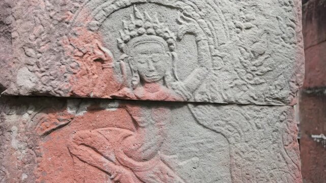 Ancient stone carvings of apsaras adorn a pillar at Kravan Temple, Angkor Wat, Siem Reap, Cambodia. These intricate reliefs showcase Khmer artistry.