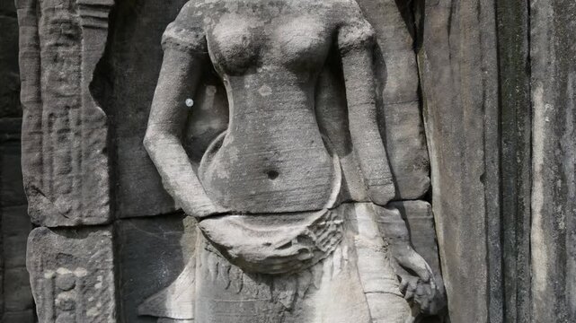 Ancient stone carving of a female deity at Angkor Wat, Siem Reap, Cambodia. The intricate details showcase the artistry of Khmer architecture.
