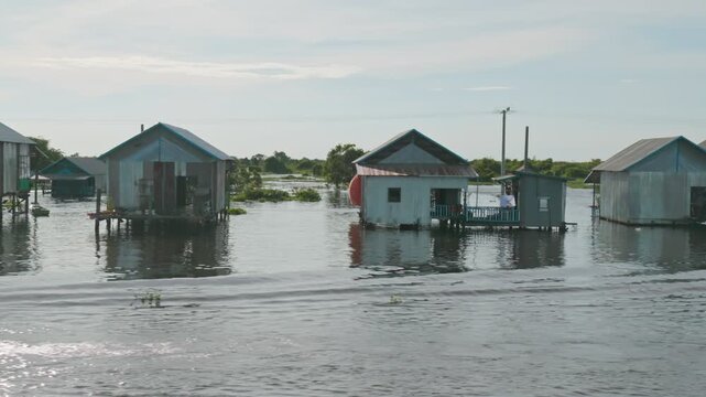 Floating houses on Tonle Sap Lake, Cambodia. This unique village showcases a way of life adapted to the seasonal water levels of Southeast Asia's largest freshwater lake.