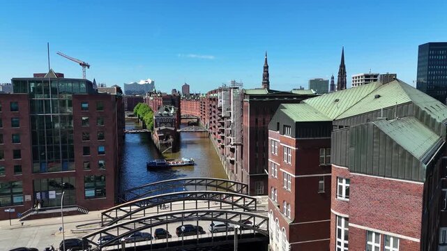 Hamburg, Germany - 28 May 2026: Aerial view of the historic Speicherstadt warehouse district featuring red brick buildings, canals, and arched bridges under a clear blue sky.