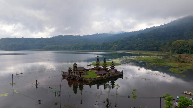Aerial drone view of Pura Ulun Danu Tamblingan temple on Tamblingan Lake, Bali