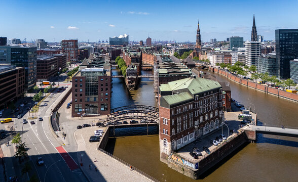Aerial view of the historic Speicherstadt warehouse district with red brick buildings, canals, and bridges under a clear blue sky in Hamburg, Hamburg, Germany.