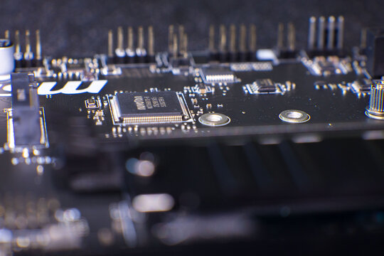 Detailed close-up image showcasing an MSI computer motherboard featuring integrated circuits, capacitors, resistors, and connectors. Focus on electronic components with visible pins and solder joints