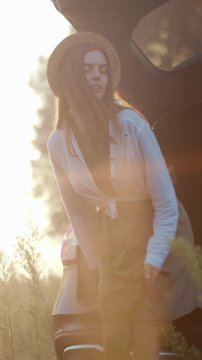 Bright moment in quiet countryside scene, Calm woman dressed in linen enjoys peaceful hours near vehicle at dusk
