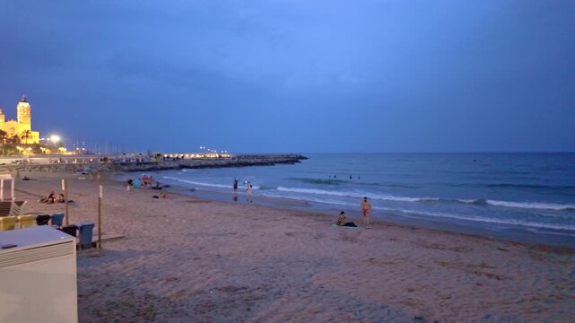 People relaxing on the beach in Sitges at night