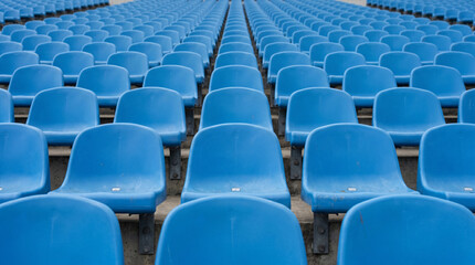 Naklejka premium Symmetrical Rows of Blue Empty Plastic Seating in an Outdoor Stadium