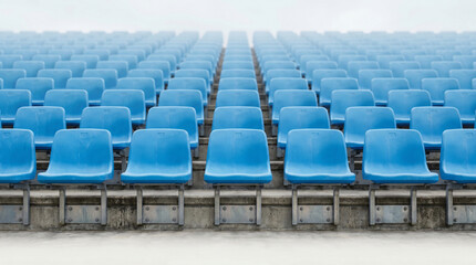 Fototapeta premium Symmetrical view of empty blue stadium seats disappearing into fog