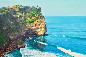      Bali, Indonesia - June 7, 2022: The Uluwatu Temple on a Cliff. Perched dramatically on a steep cliff, Uluwatu Temple stands at an elevation of 97 meters above sea level, offering breathtaking oce © Scotts Travel Photos