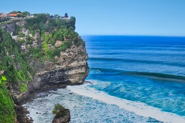      Bali, Indonesia - June 7, 2022: The Uluwatu Temple on a Cliff. Perched dramatically on a steep cliff, Uluwatu Temple stands at an elevation of 97 meters above sea level, offering breathtaking oce © Scotts Travel Photos