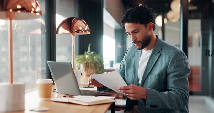 Business, documents and laptop with man in coffee shop for hybrid work, planning or research. Computer, paperwork and reading with employee at window in cafe or restaurant for information review