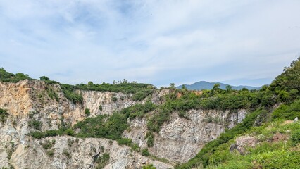 Fototapeta premium An old canyon where crushed stone production has ceased. The canyon is overgrown with plants.