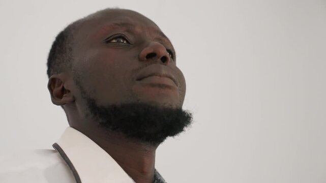 White shirted man confronts distress. Individual dressed in white battles deep emotional turmoil silently. Man wearing white experiences profound emotional suffering and silently hides his face
