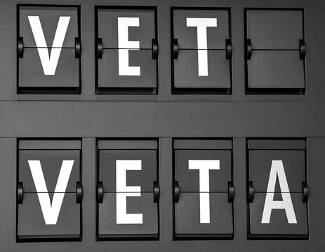 Black Split Flap Letter Board Displaying Vet and Veta on Gray Background