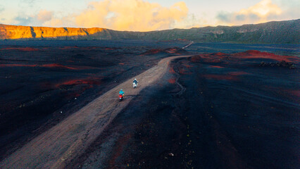 Vue aérienne de randonneurs traversant la plaine volcanique du Piton de la Fournaise au lever du soleil, île de La Réunion © Alexis